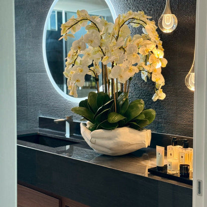 White Phalaenopsis orchids in a vase, open hands sculpture